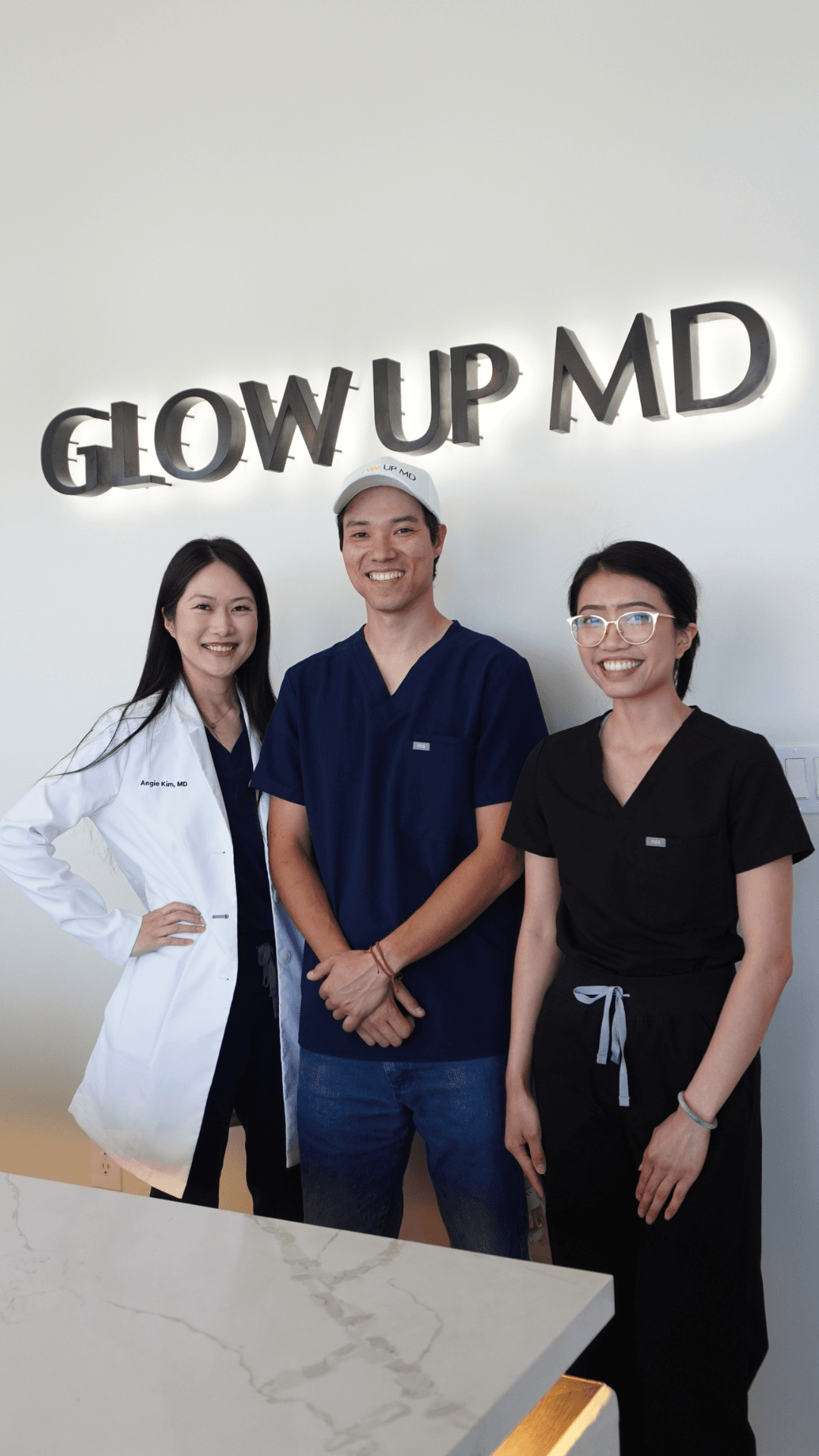 A medical aesthetics team standing together beneath a Glow Up MD sign
