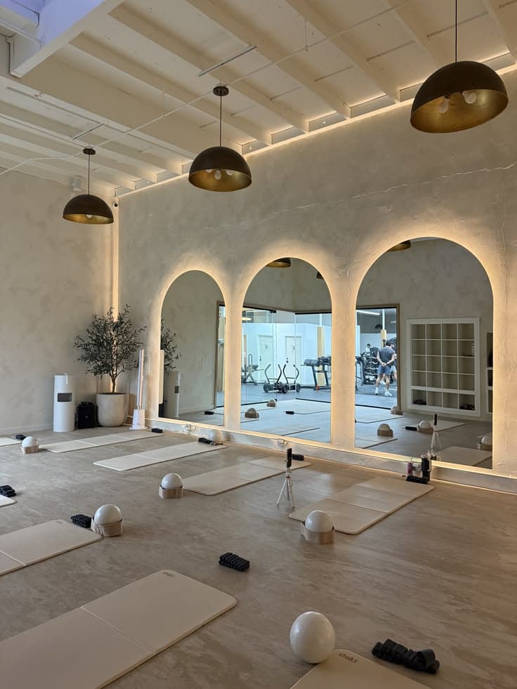 Pilates studio interior with reformers and warm natural light