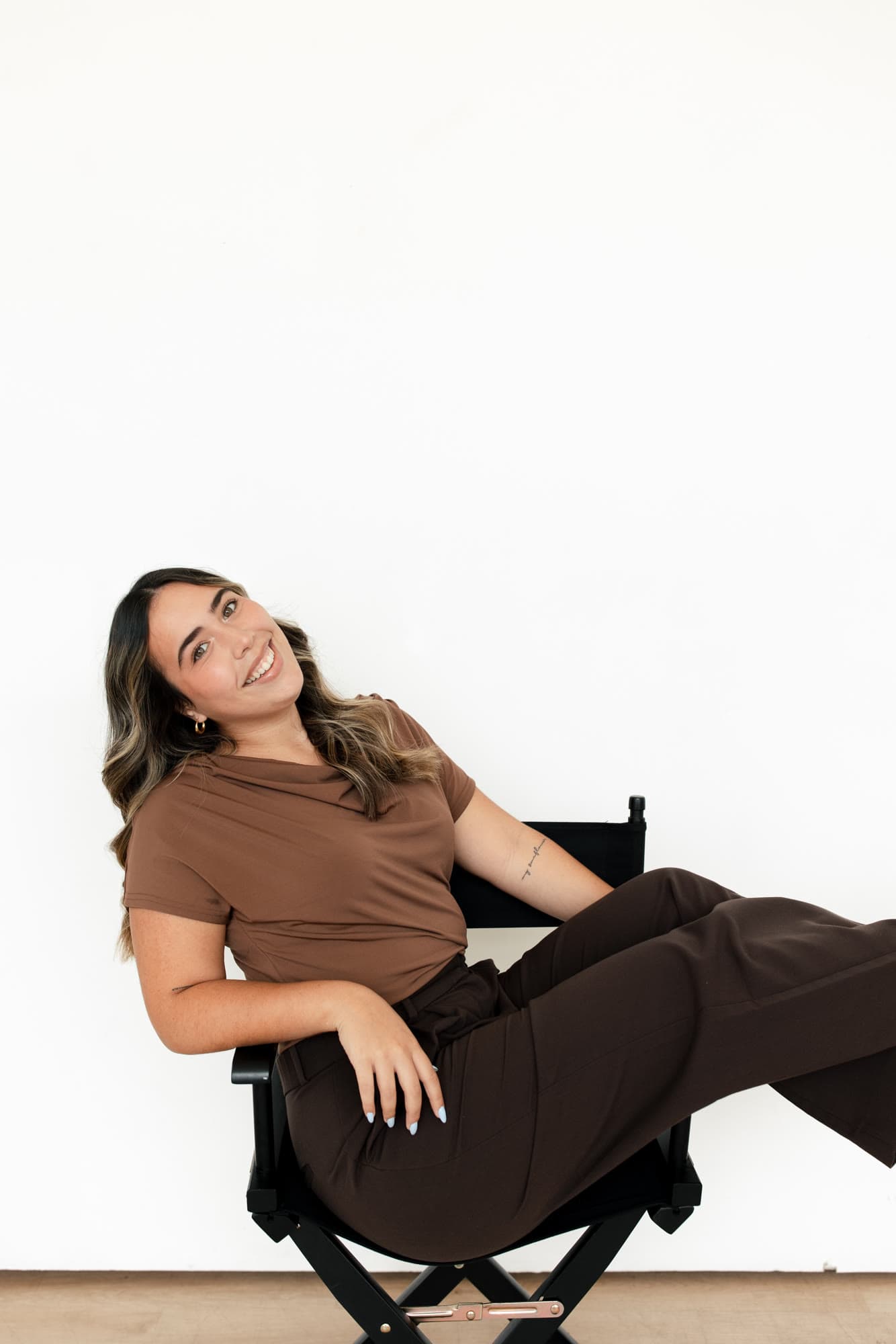 Valeria smiling from a director chair in a bright studio