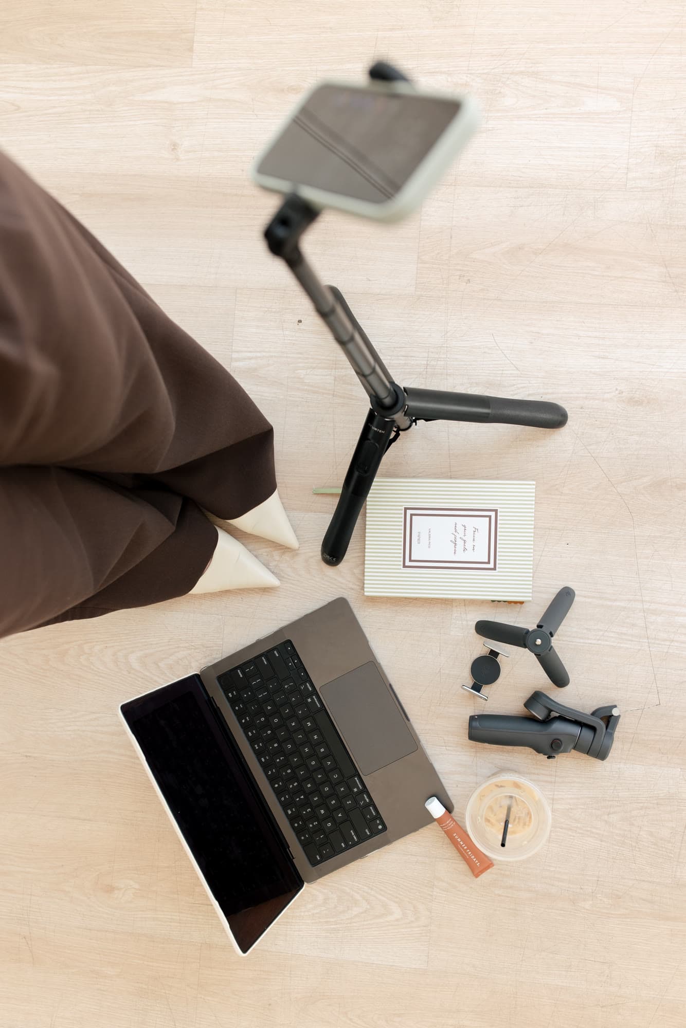 Overhead view of a laptop, camera rig, tablet, and content-planning notes