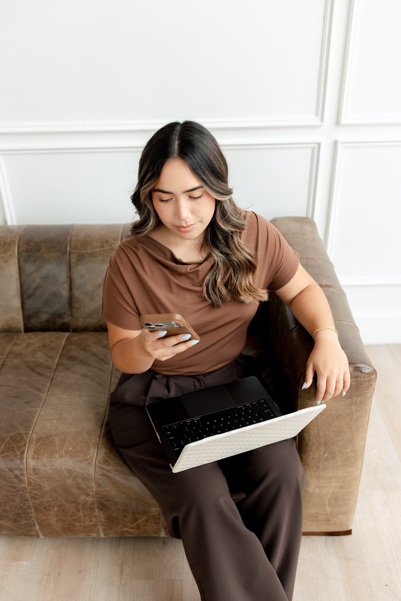 Valeria seated in the studio reviewing creative work on a tablet