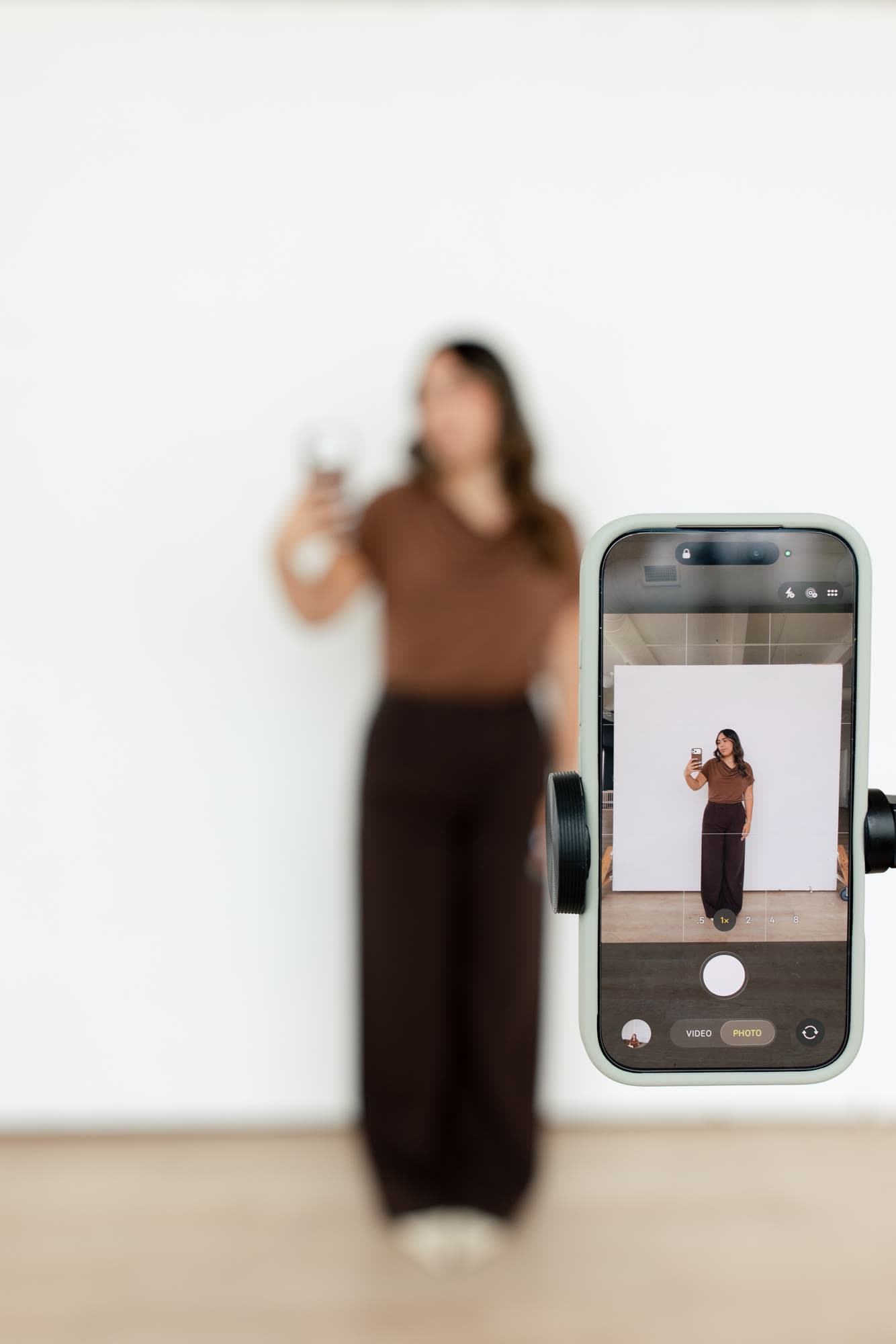 Valeria framed through a phone during a vertical content shoot
