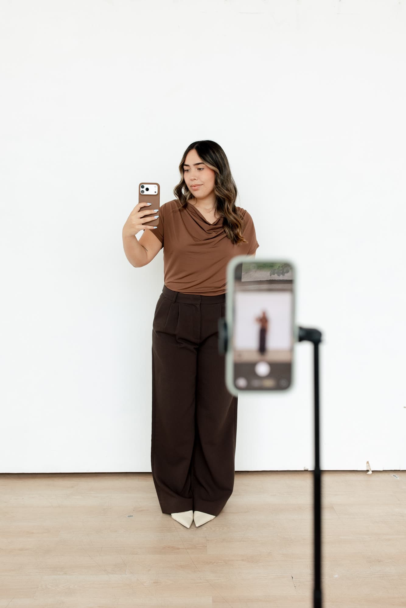 Valeria standing behind a phone and tripod in the studio